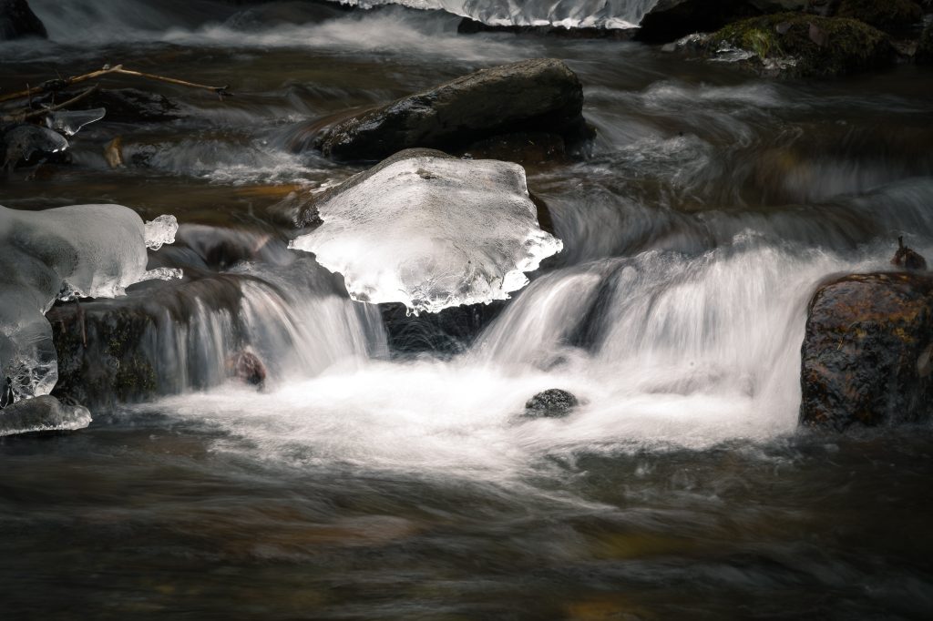 Plaque de glace posée sur des rochers dans un torrent de montagne, Pyrénées